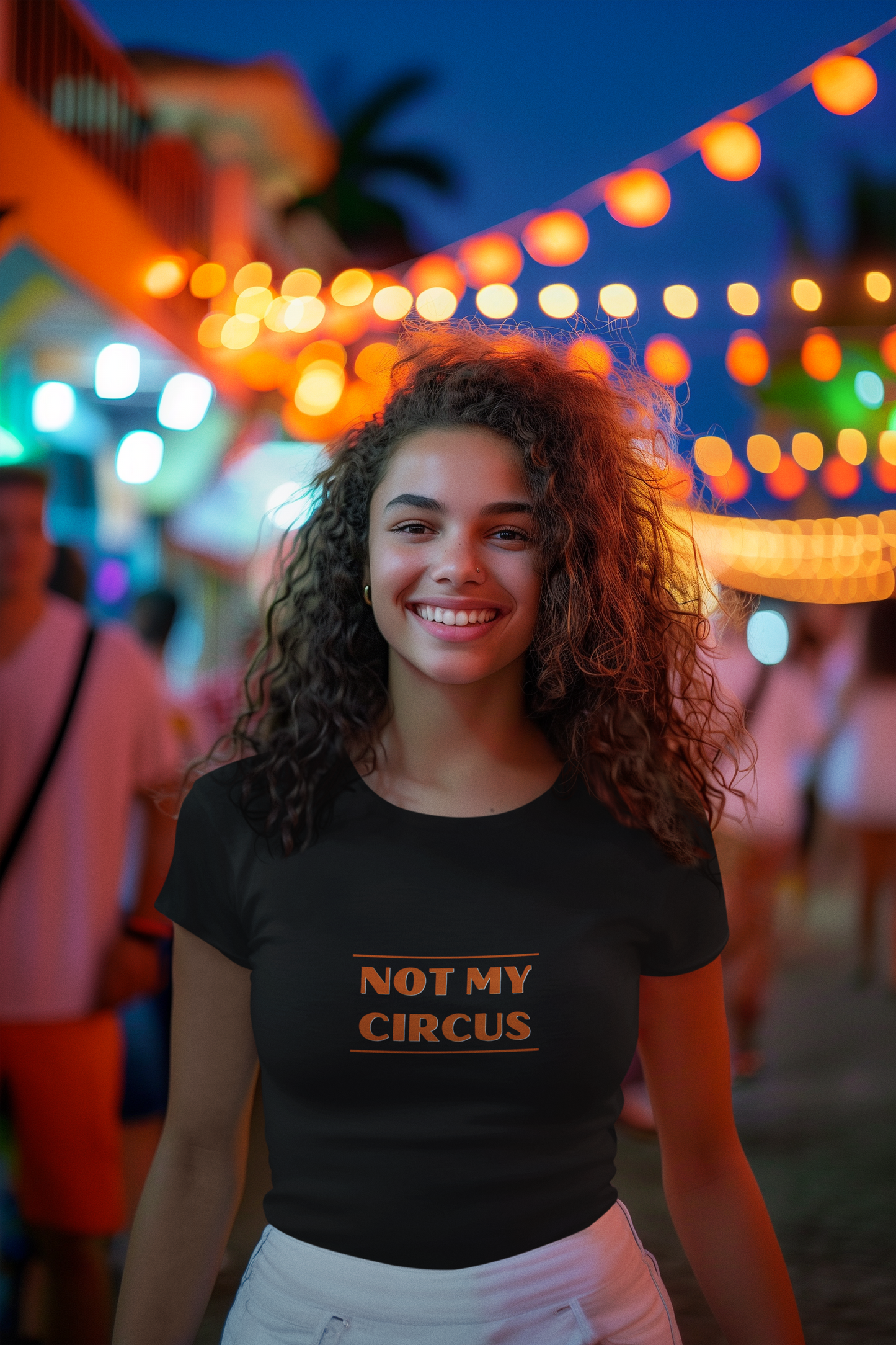 A young female with curly hair wearing a black organic cotton unisex t-shirt with the slogan 'not my circus' written in bright orange across the chest.
