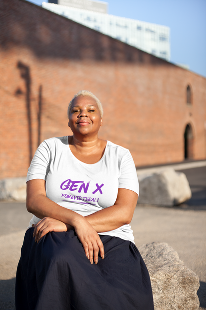 A plus-size POC Gen X female sits wearing a white organic cotton unisex t-shirt with the words Gen X Forever Feral across the chest in purple.