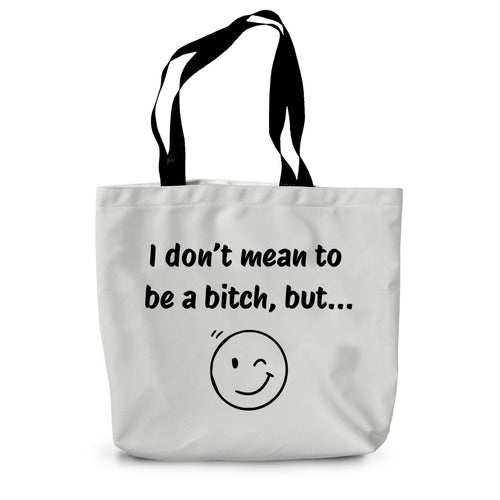 A white canvas tote bag with long black handles and a winky face on the side beneath the words 'I don't mean to be a bitch, but...'