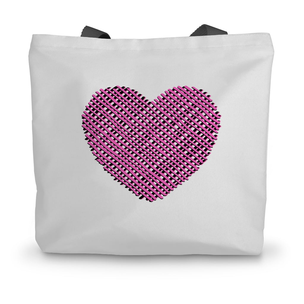 A white canvas tote bag with black handles and a pink heart design on the side.