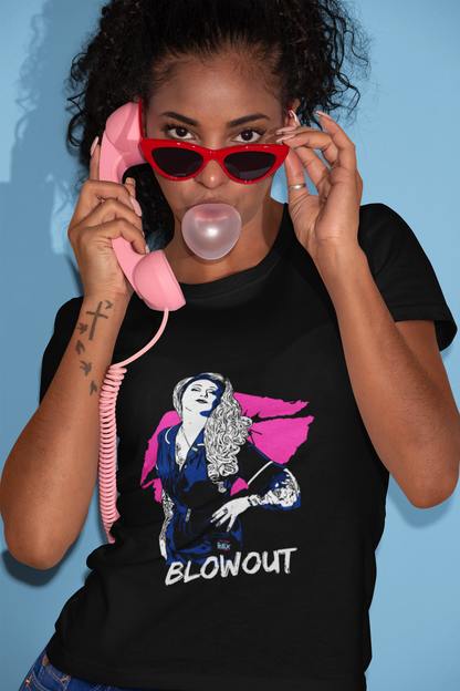 A young female person of colour wearing a black unisex crew neck t-shirt with a cartoon picture of Brandy Bex on the front above the word Blowout in white. 